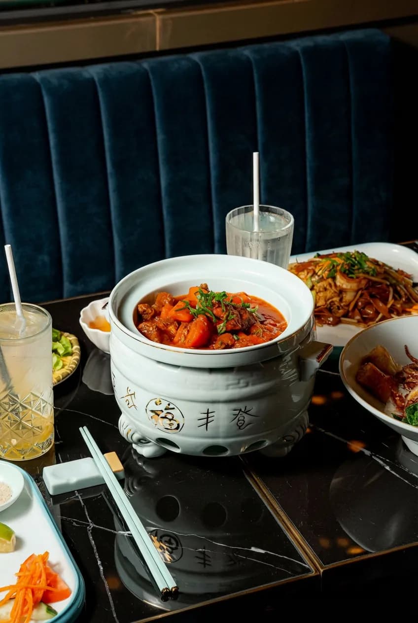 Marmite sur table de marbre noir, banquette velours en arrière-plan